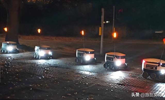一群送货机器人在英国剑桥无法过马路，呼叫女士帮助按通行按钮